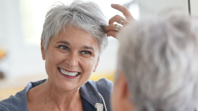 Woman touching her gray hair